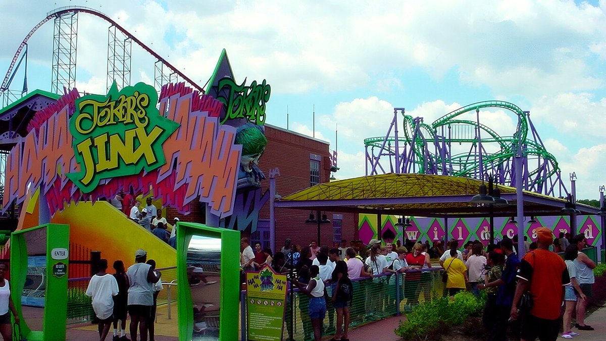 The entrance area of a major amusement park with roller coaster tracks visible in the background.